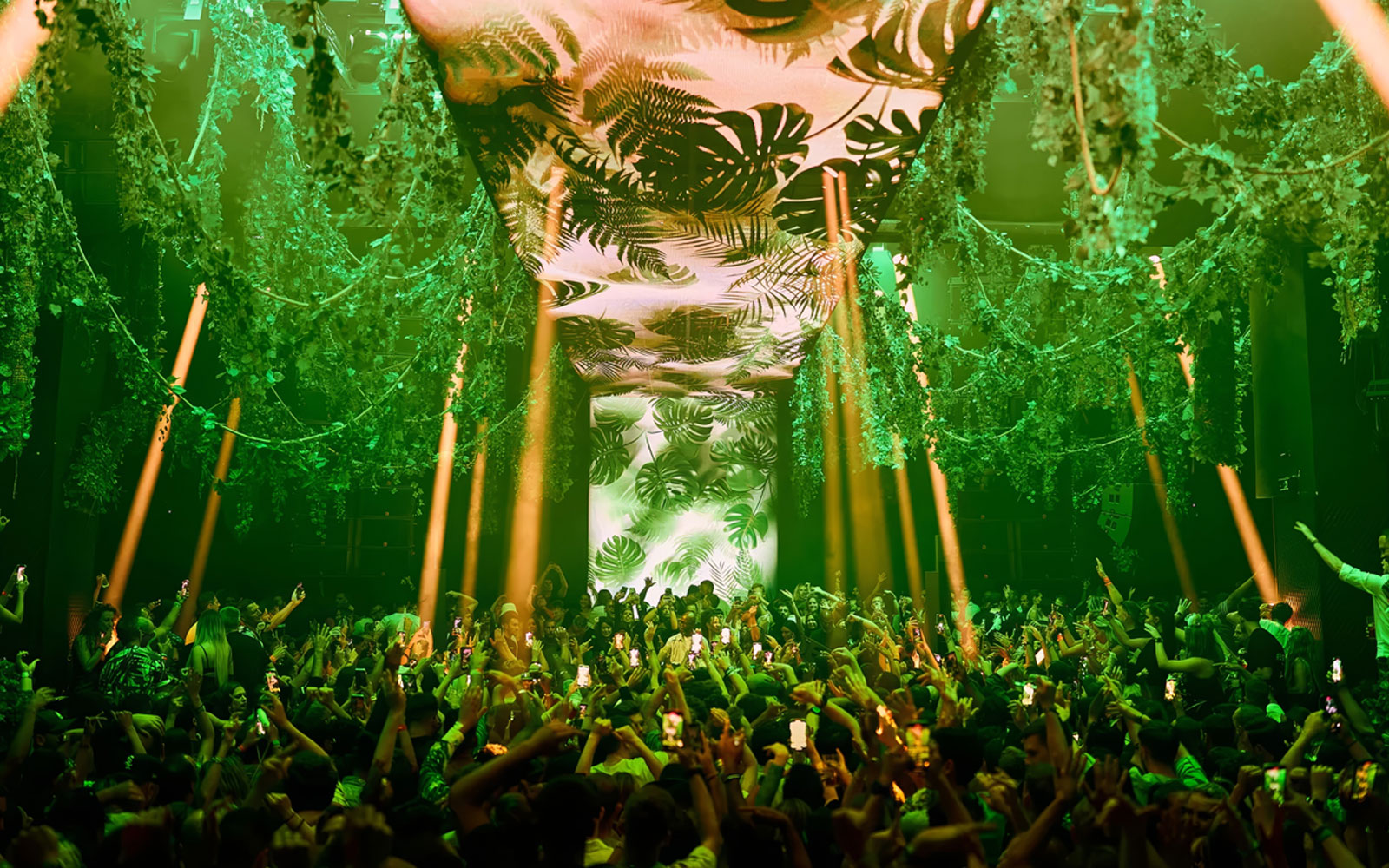 Crowd enjoying Black Coffee performance at Hi Ibiza with vibrant green decor.