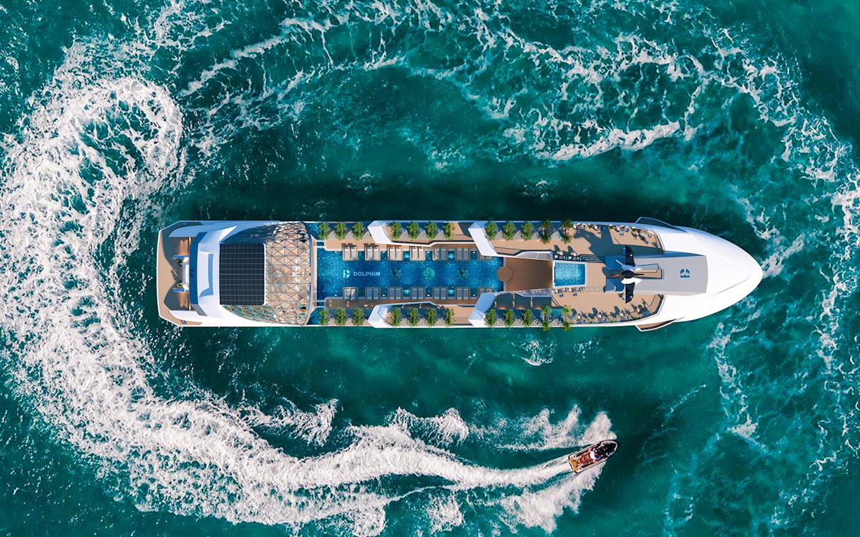 Aerial view of a luxury cruise ship with an infinity pool and sun loungers on deck.