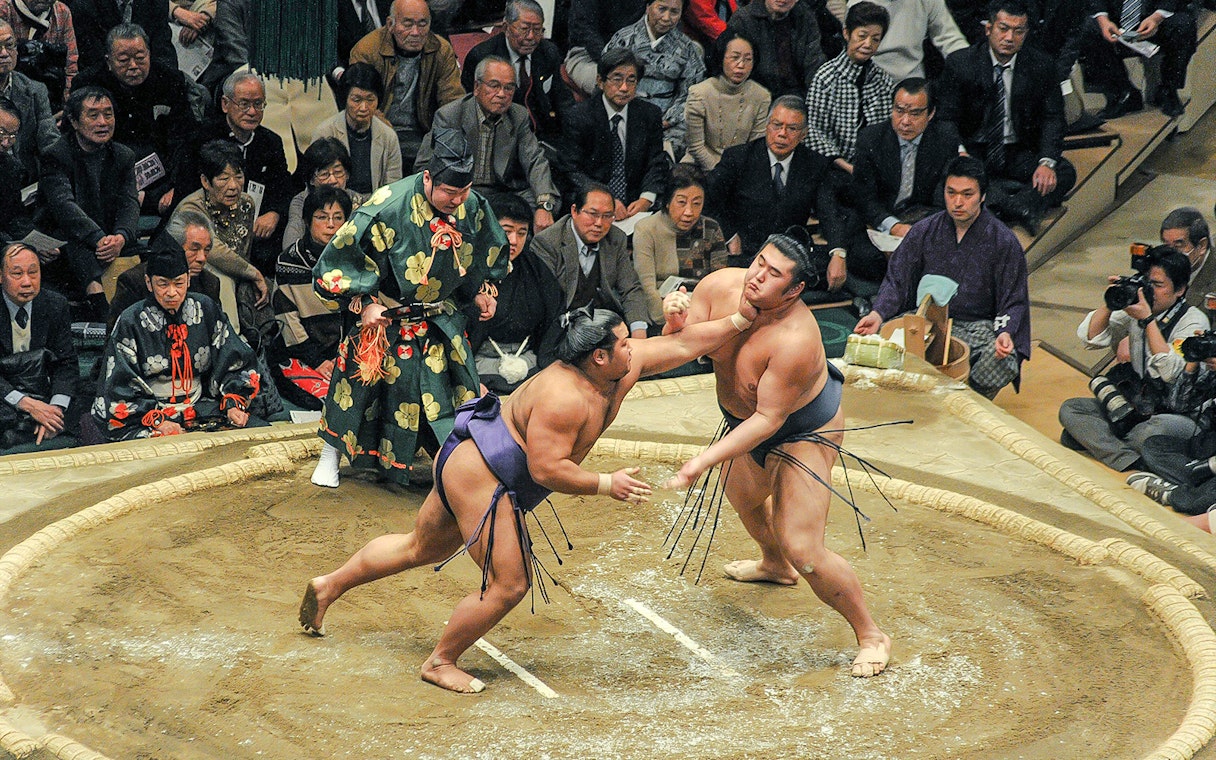 Sumo wrestlers engage in a match during a tournament in Tokyo.