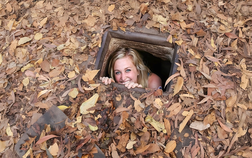 Woman emerging from Cu Chi tunnel in Vietnam.