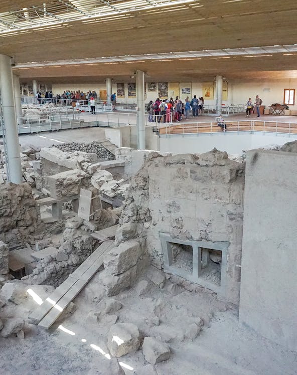 Visitors exploring ruins at Akrotiri Archaeological Site, Santorini.