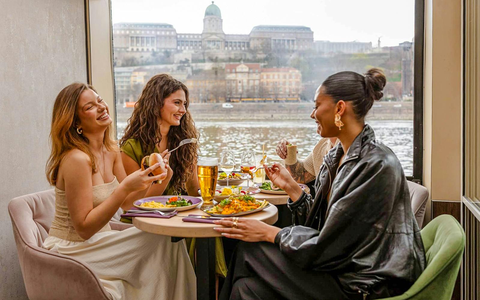 Guests dining with river view on Margaret Island Loop tour in Budapest.