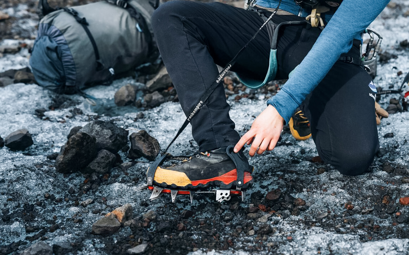 Guest adjusting crampons on glacier tour.