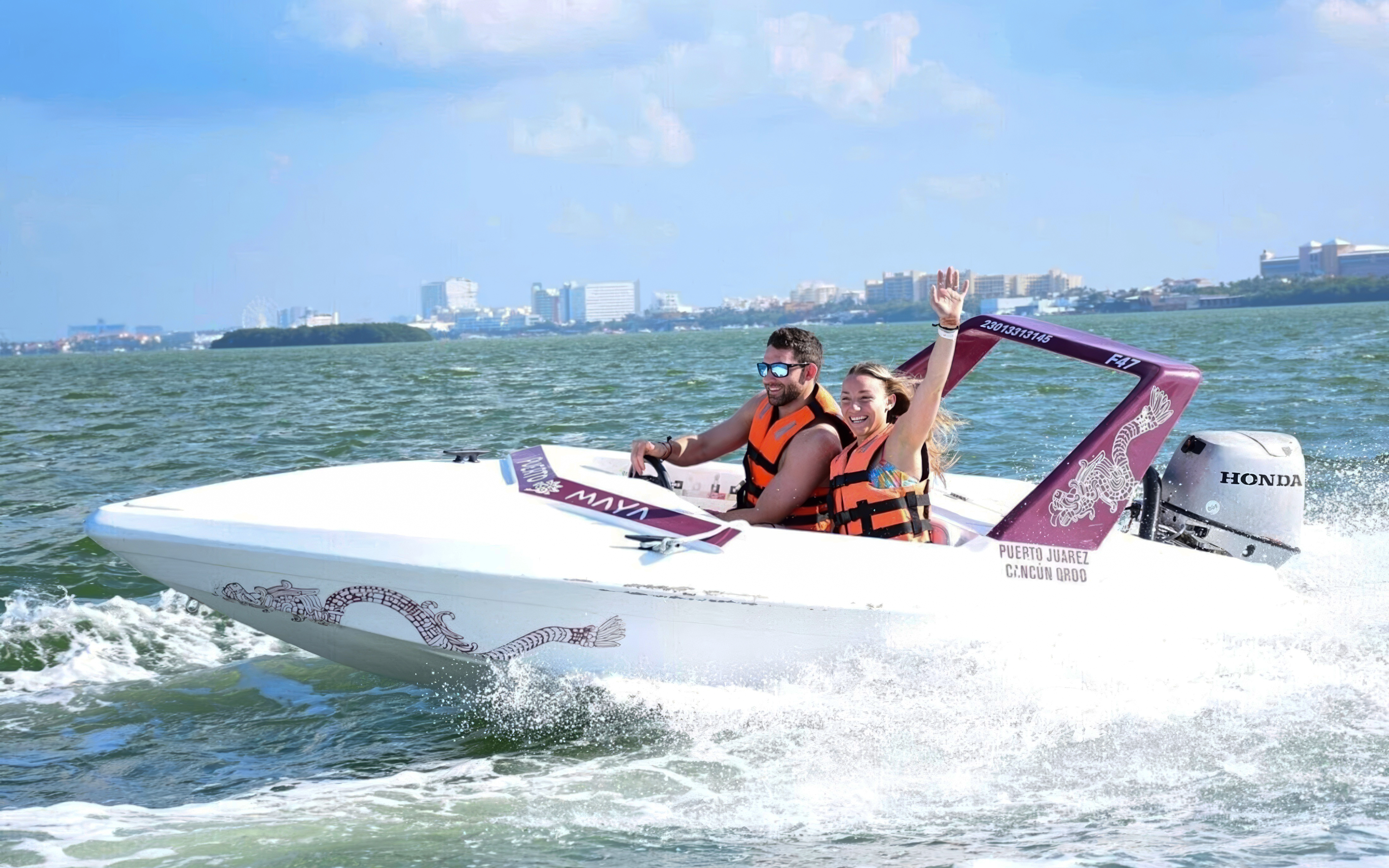 Speedboat ride on Cancun waters with city skyline in background.