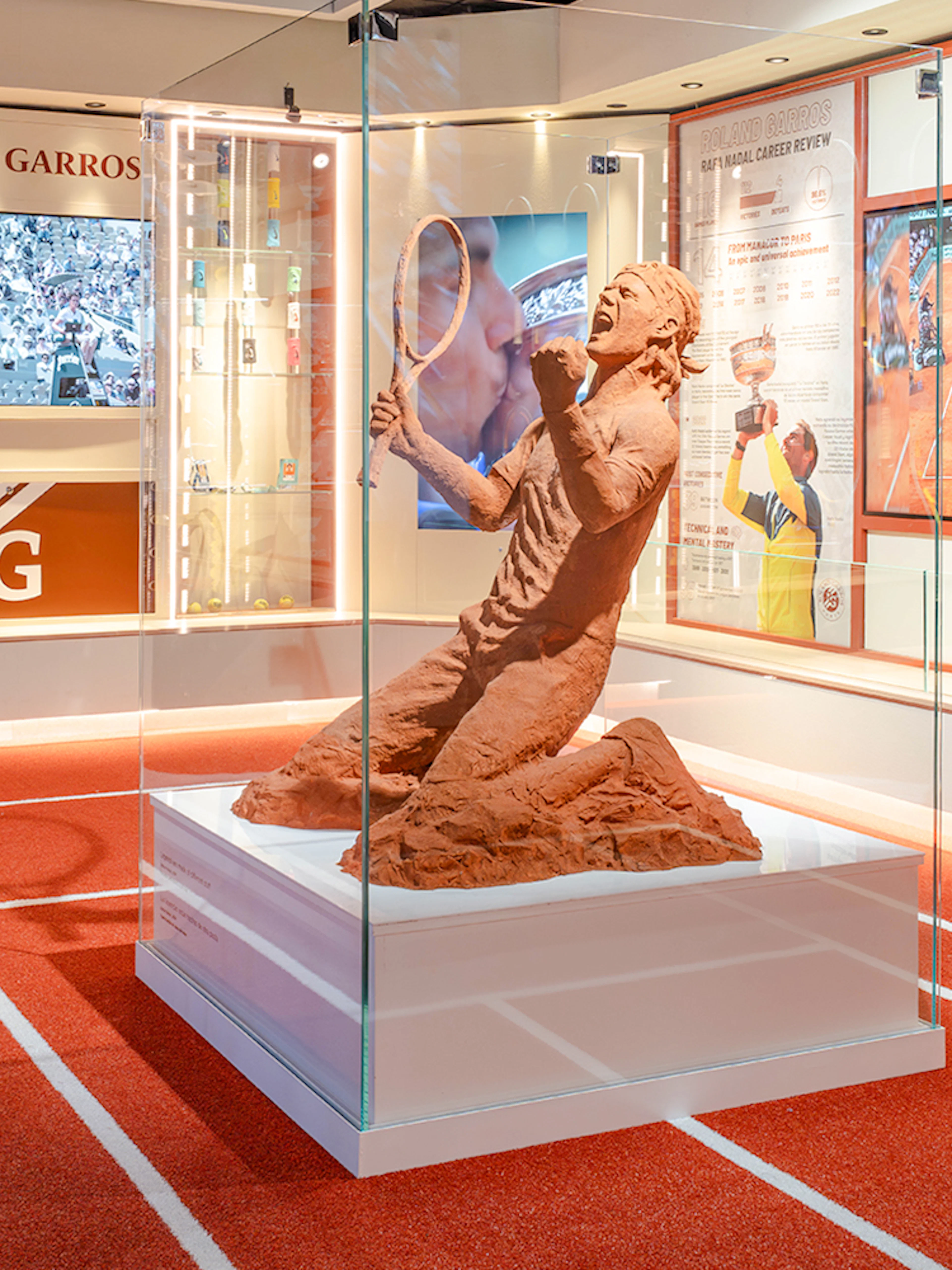 Clay sculpture of a tennis player at Rafa Nadal Museum Xperience, featuring Roland Garros memorabilia.