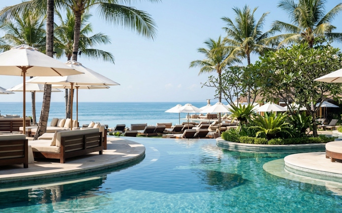 Finn's Beach Club poolside with ocean view and palm trees in Bali.