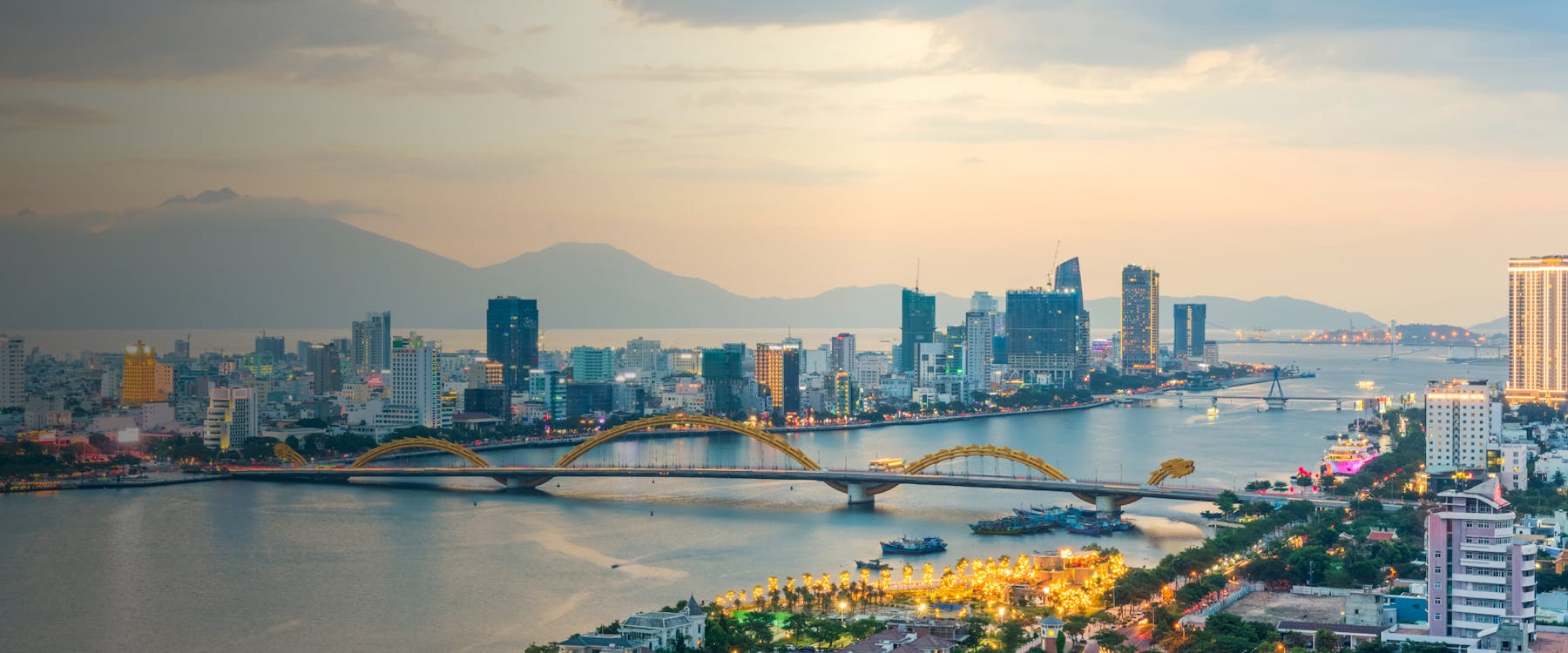 Da Nang skyline with Dragon Bridge spanning the Han River at sunset.