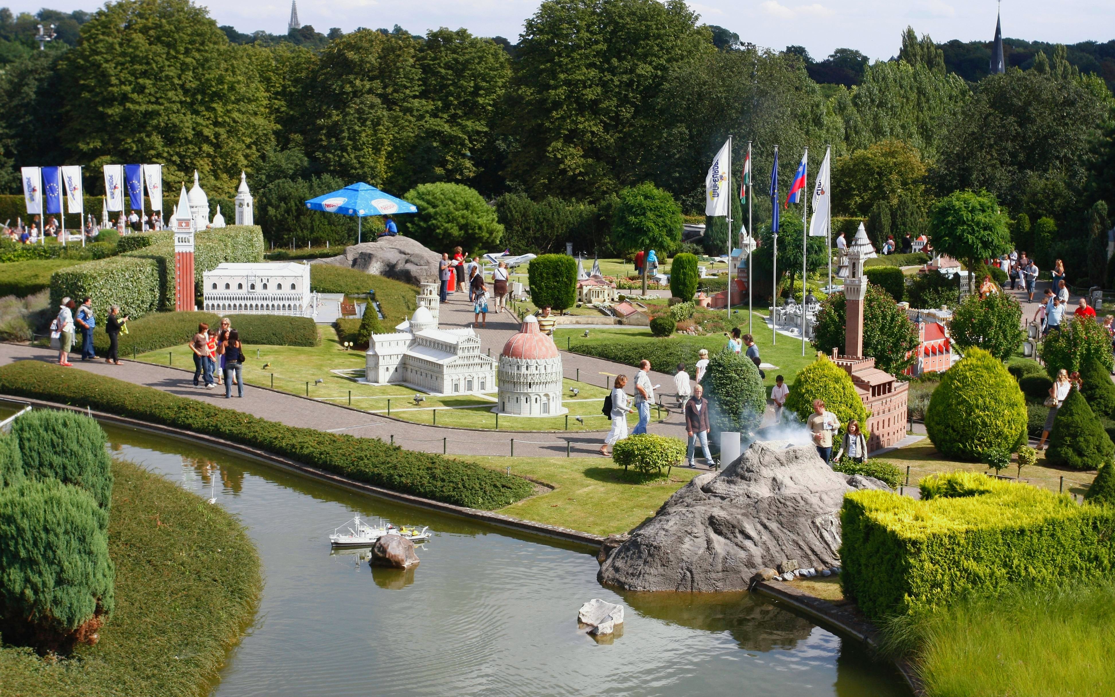 Mini-Europe park with visitors exploring miniature landmarks and a canal in Brussels, Belgium.