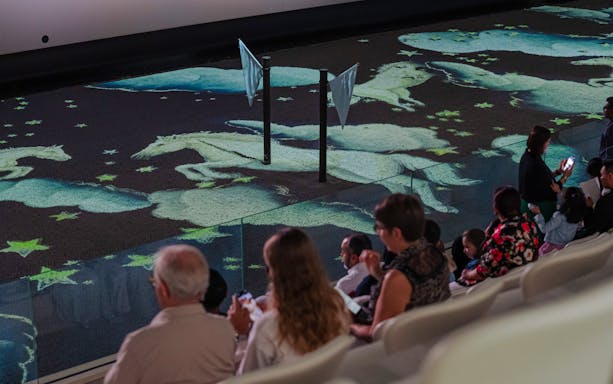 Audience watching horse projections at Abu Dhabi Royal Equestrian Arts show.