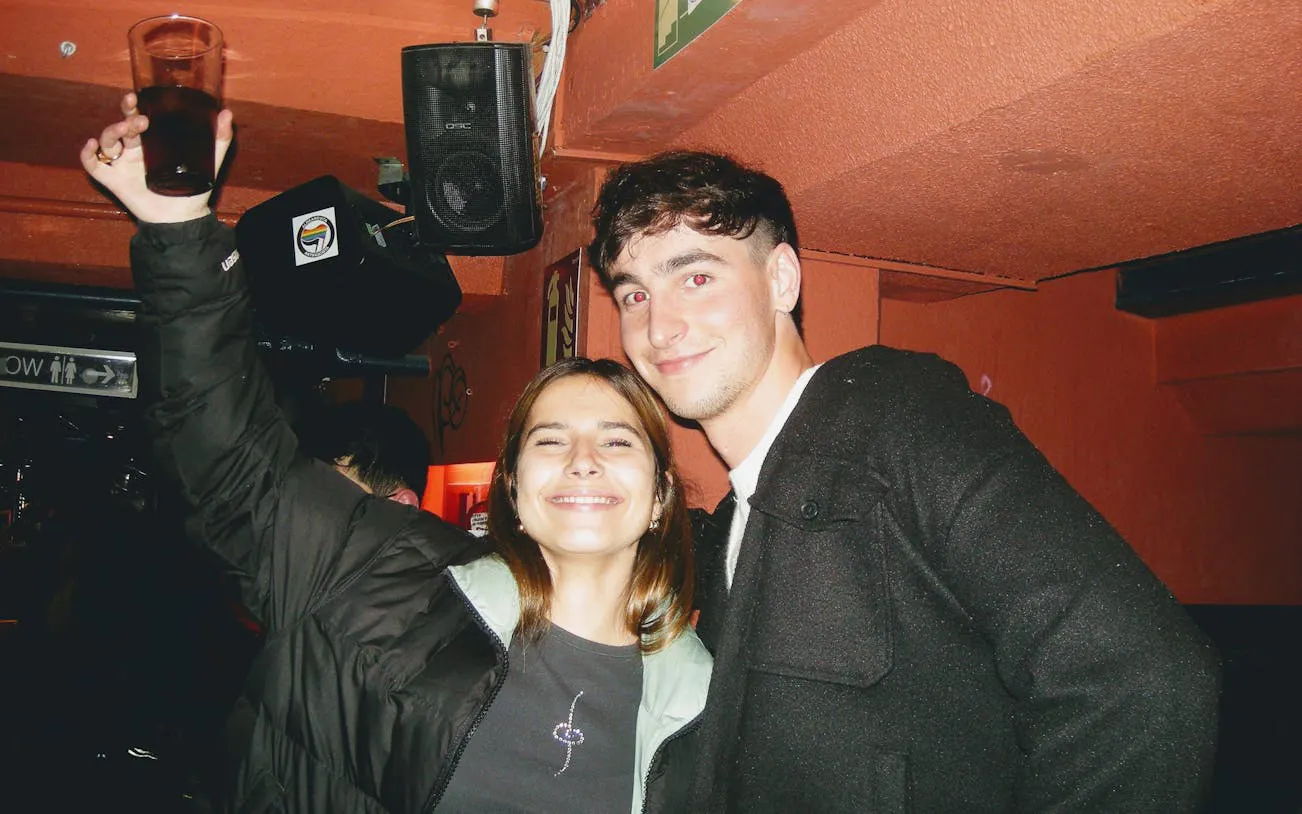 People enjoying a night out during a Barcelona pub crawl with guided bar visits.