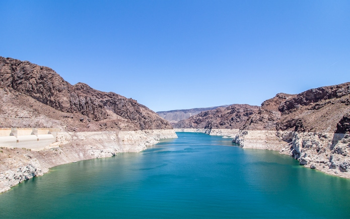 Hoover Dam banks along Colorado River with rocky cliffs and blue water.