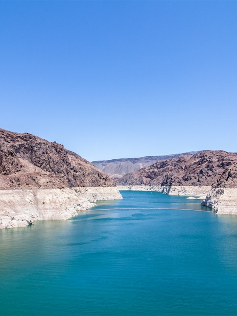 Hoover Dam banks along Colorado River with rocky cliffs and blue water.