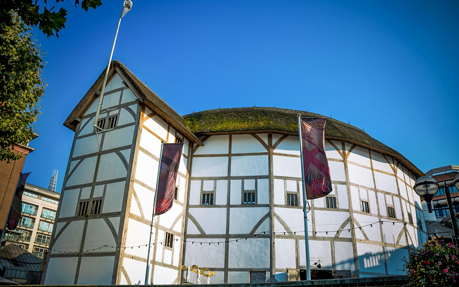 Shakespeare's Globe Theatre exterior in London with tourists gathered outside.
