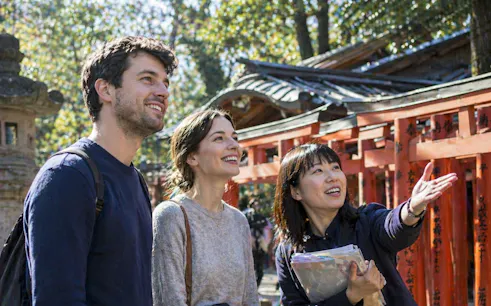Tour guide showing Nezu Shrine to visitors on Tokyo Yanaka Old Town walking tour.