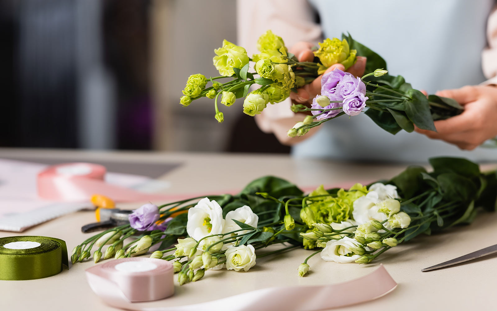 Flower arrangement in progress at Chateau de Chenonceau workshop, featuring green and purple blooms.