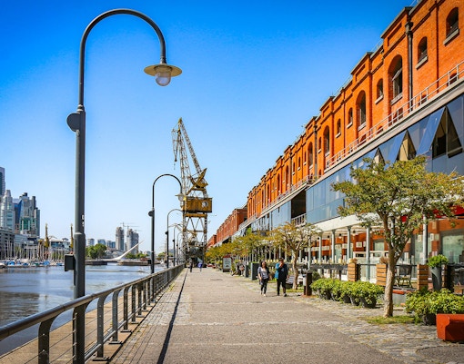 Waterfront promenade with red brick buildings and cranes in Puerto Madero, Buenos Aires, Argentina.