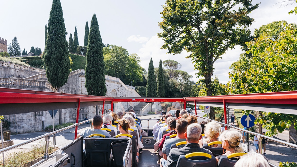 Tourists enjoying the City Sightseeing 24/48/72-Hr Hop-On Hop-Off Tour of Florence, Italy, with a view of the city's historic architecture and landmarks