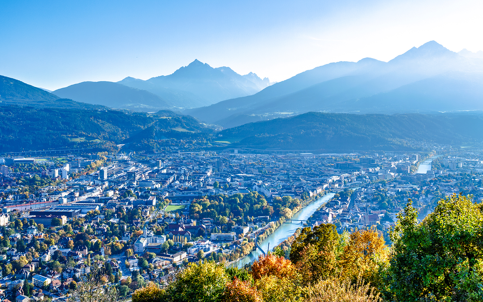 Hungerburg view of Innsbruck cityscape with mountains and river.