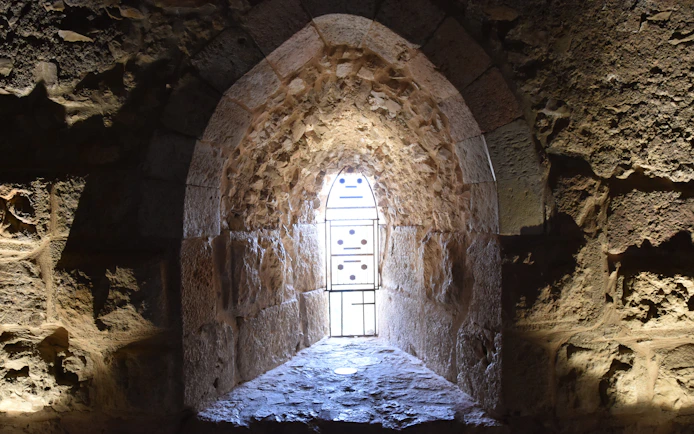 Vaulted stone window frame at Ajloun Castle, Jordan, with intricate arabesque design.