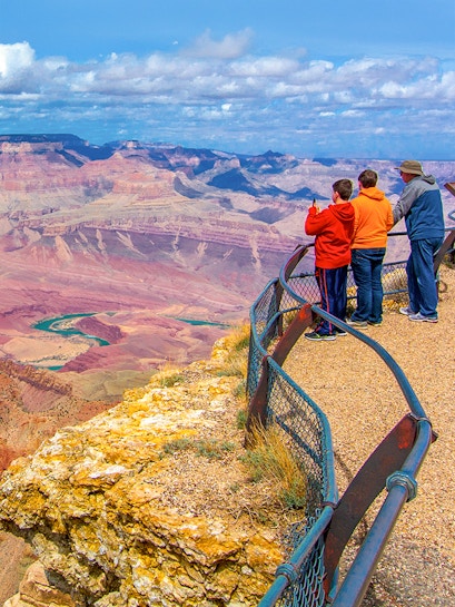 Visitors at a Grand Canyon overlook with expansive canyon views.