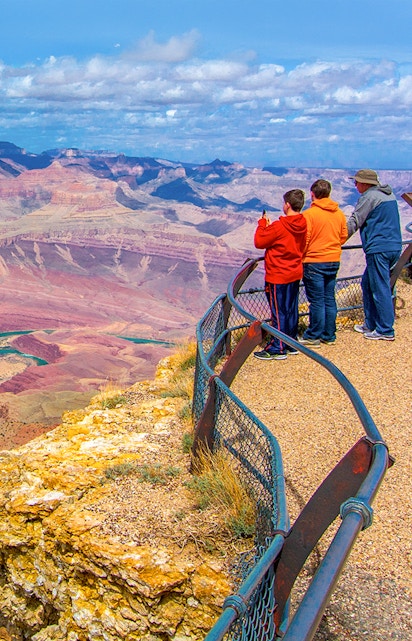 Visitors at a Grand Canyon overlook with expansive canyon views.