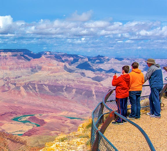 Visitors at a Grand Canyon overlook with expansive canyon views.