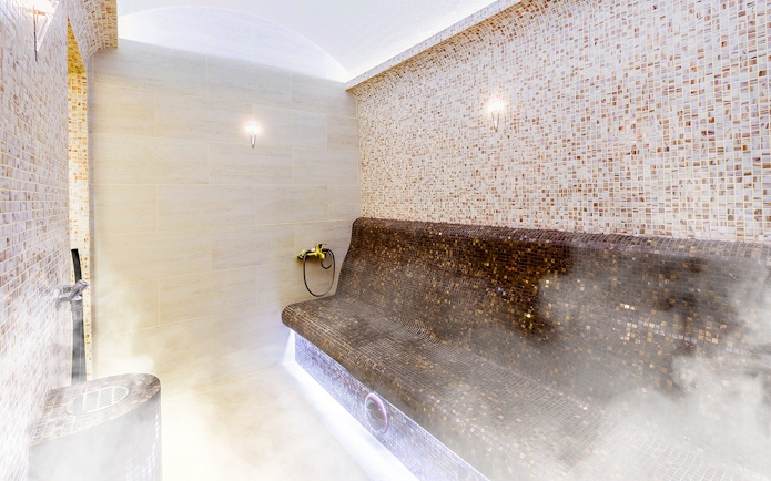 Turkish sauna interior with mosaic tiles and steam.