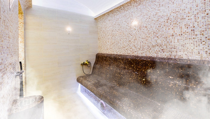 Turkish sauna interior with mosaic tiles and steam.