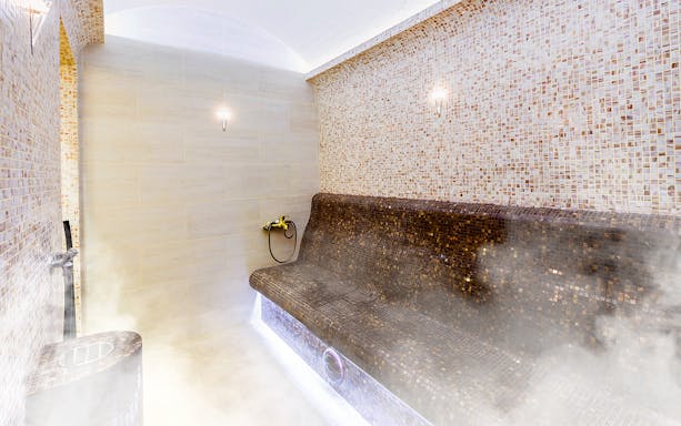 Turkish sauna interior with mosaic tiles and steam.