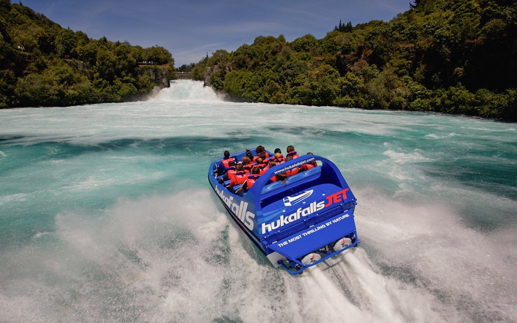 Tourist jet boat speeding towards Huka Falls, New Zealand.
