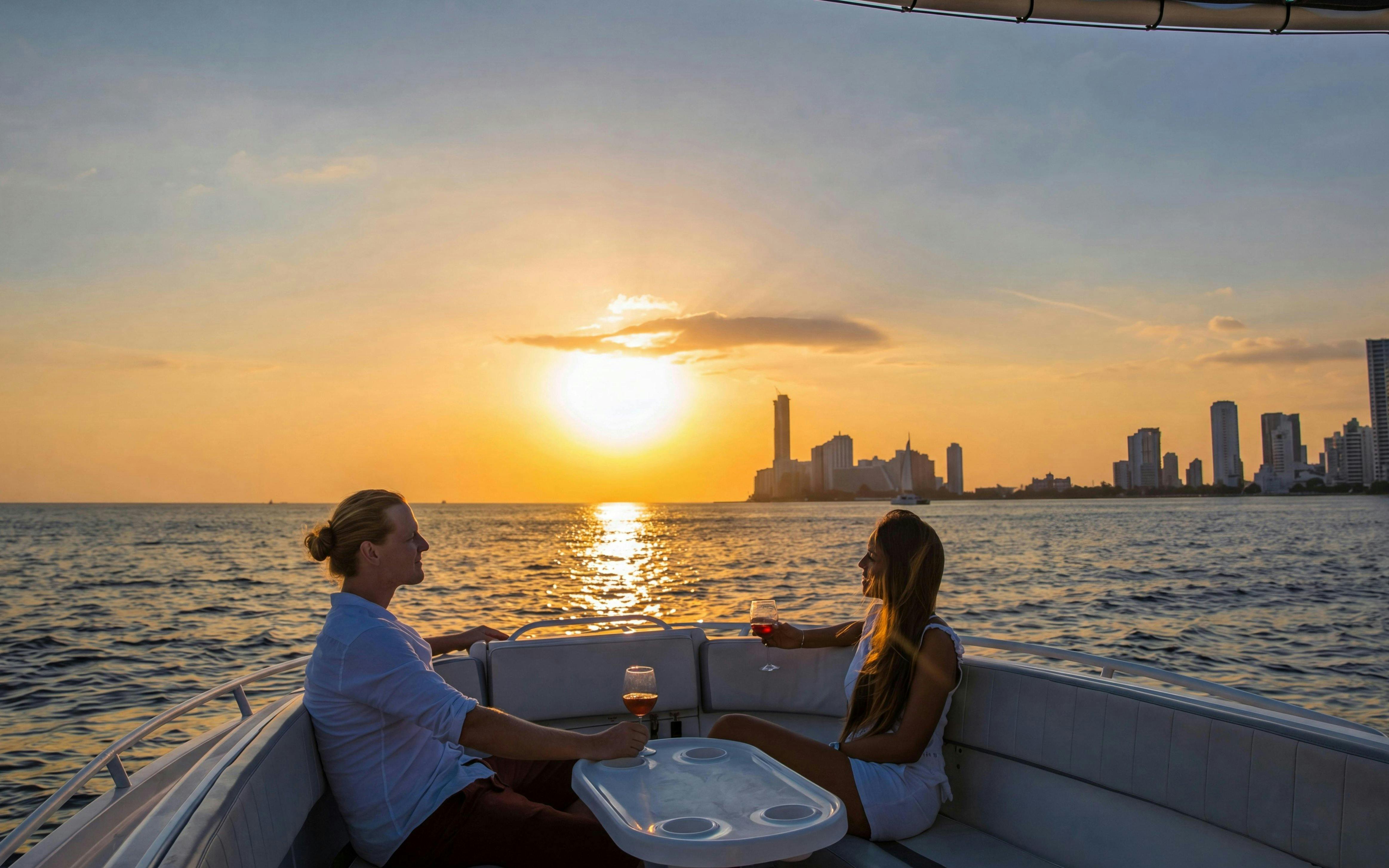 Tourists enjoying a sunset boat party in Cartagena Bay with city skyline.