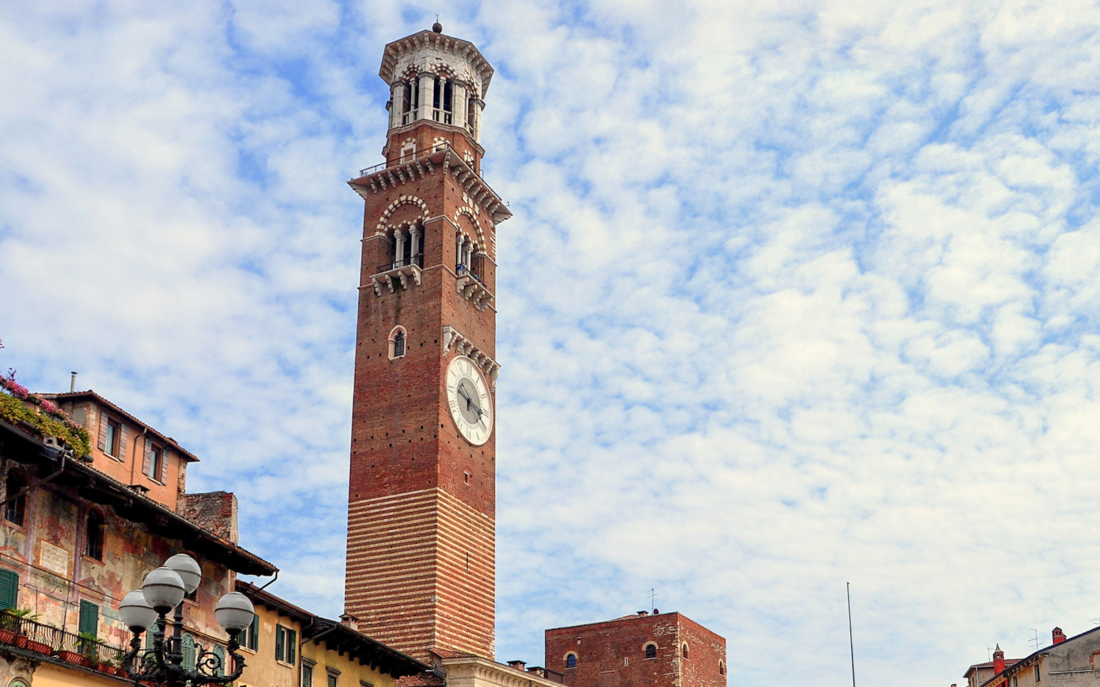 Torre dei Lamberti in Verona, Italy, under a cloudy sky.