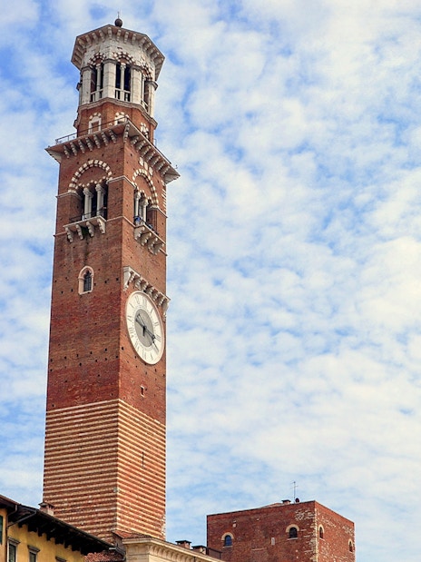 Torre dei Lamberti in Verona, Italy, under a cloudy sky.