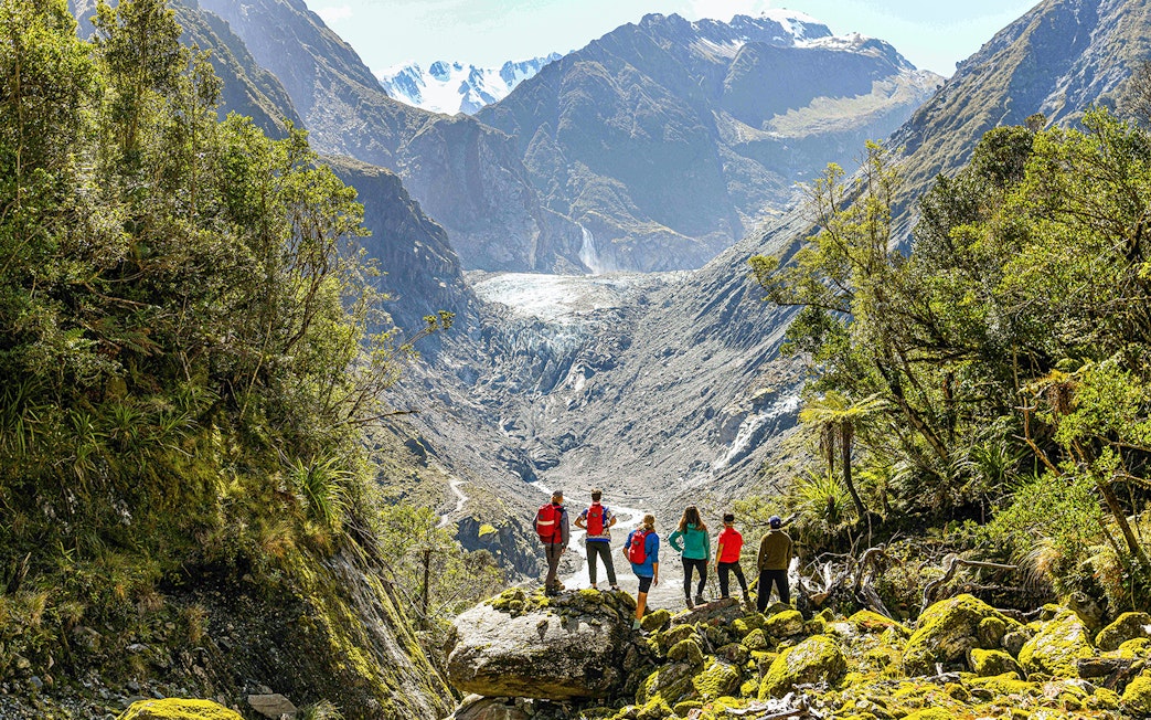 Tour group viewing Fox Glacier Valley on guided e-bike and hiking tour.