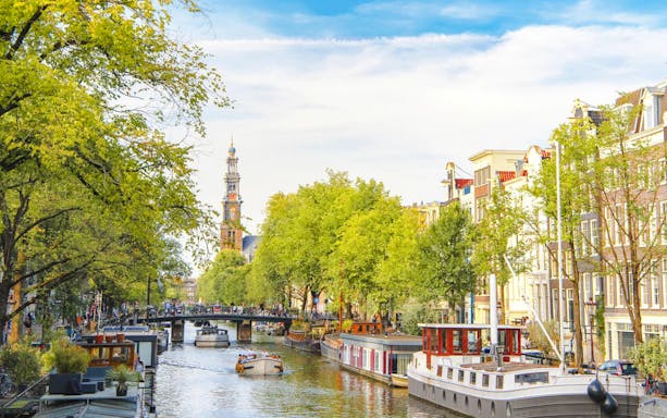 Amsterdam Red Light District canal with historic buildings and illuminated windows at night.