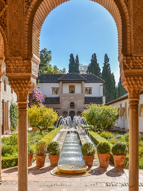 Alhambra courtyard with arches and fountain, Granada day trip from Seville.