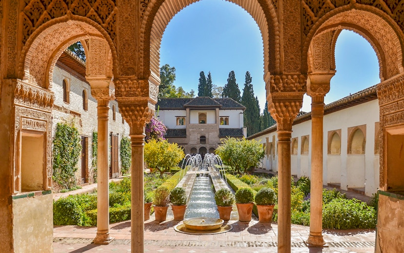 Alhambra courtyard with arches and fountain, Granada day trip from Seville.