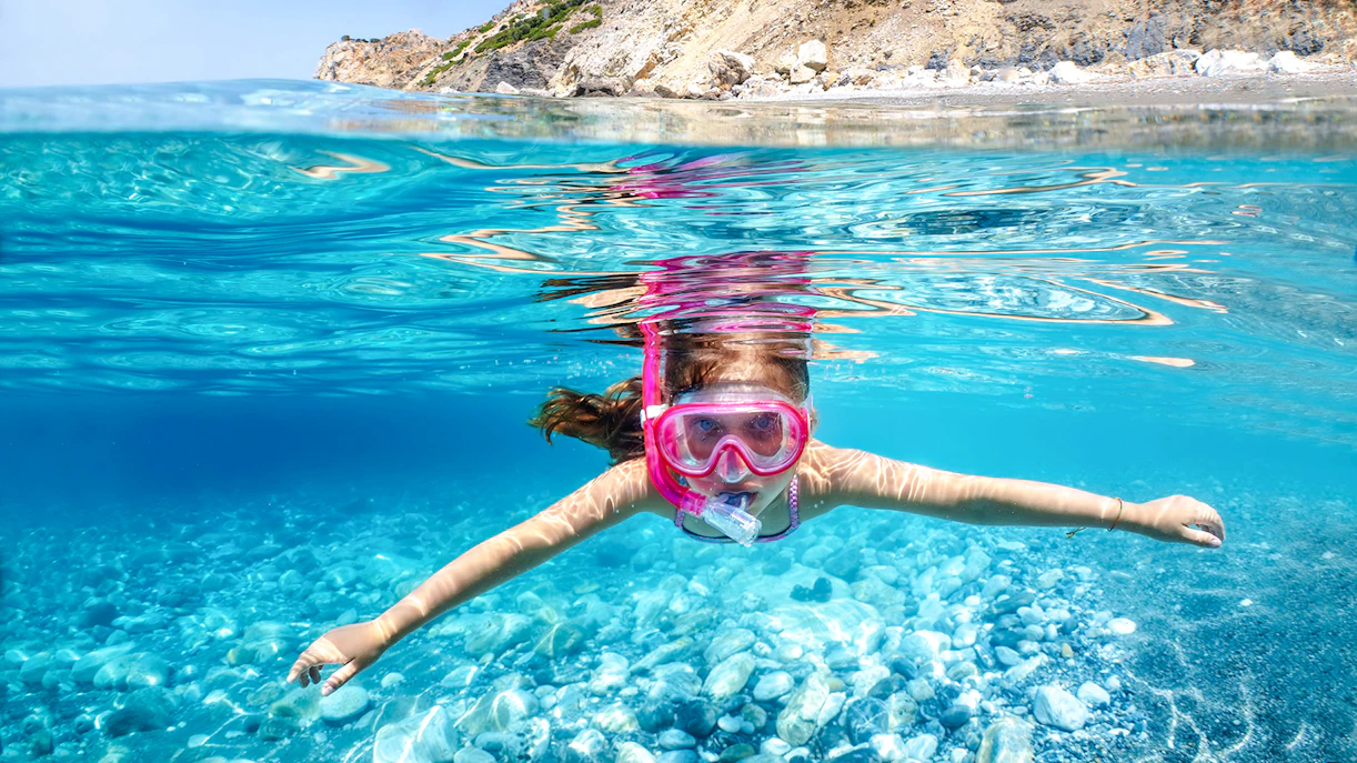 Snorkeler exploring clear waters in Santorini, Greece.