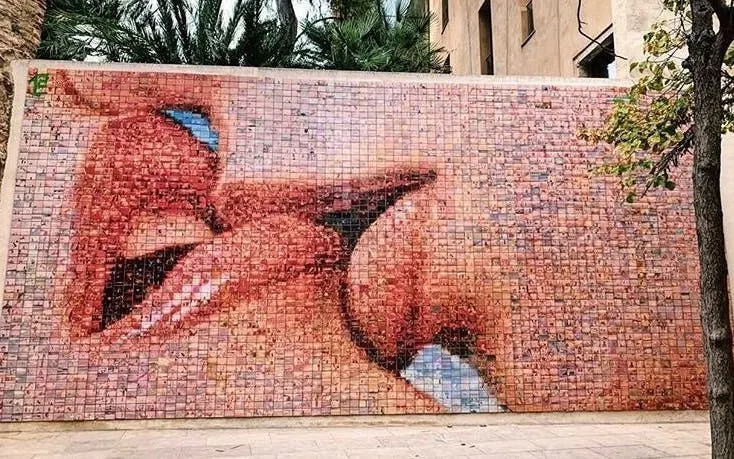 Mosaic mural of kissing lips in Barcelona, part of a self-guided city exploration game.