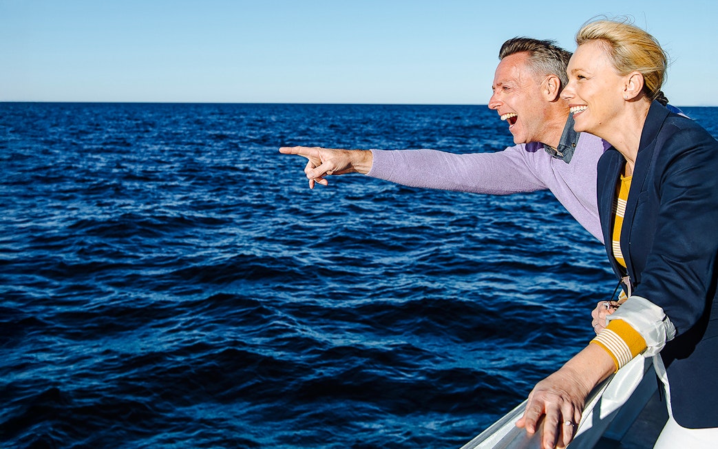 Couple enjoying whale watching tour on a boat in Sydney.