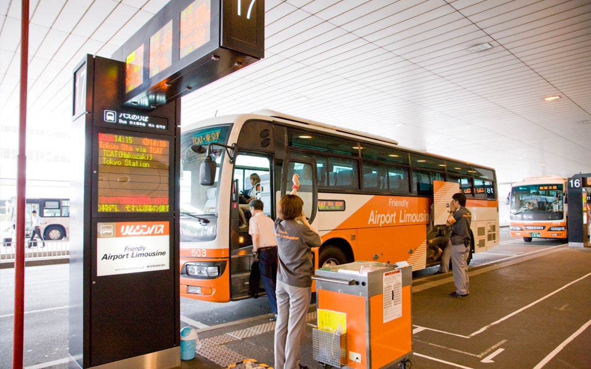 Staff assisting passengers at Tokyo Airport Limousine Bus stop.