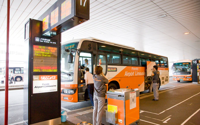 Staff assisting passengers at Tokyo Airport Limousine Bus stop.