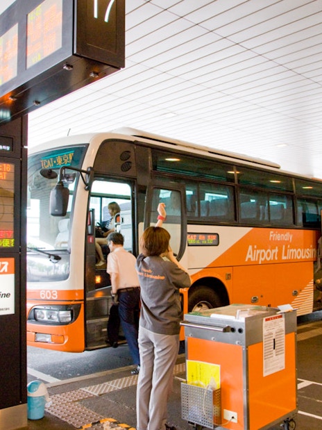 Staff assisting passengers at Tokyo Airport Limousine Bus stop.