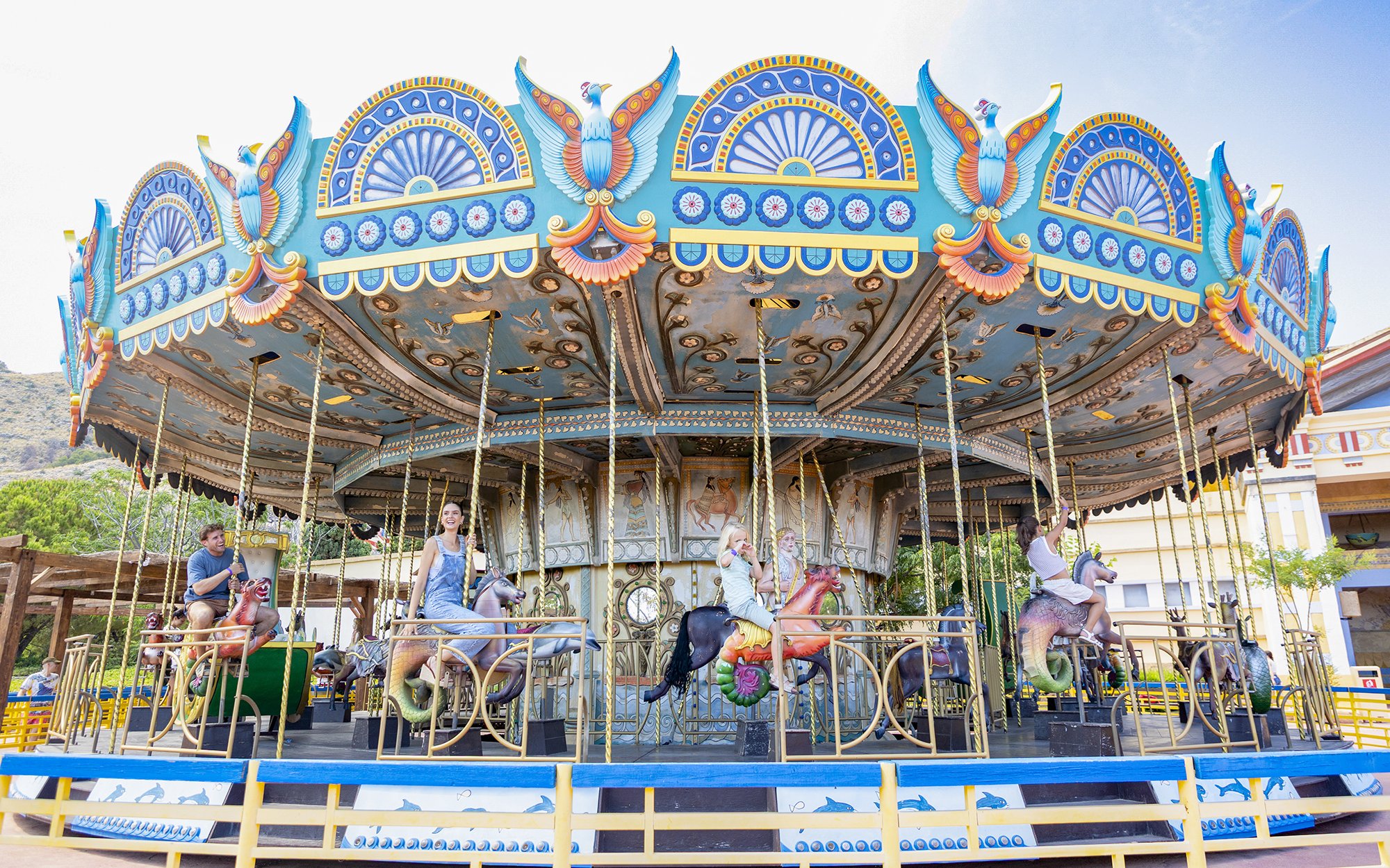 Carousel ride at Terra Mitica Benidorm with colorful decorations and people enjoying the attraction.