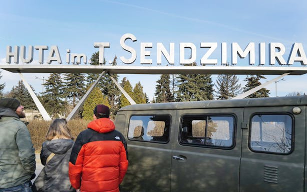 Visitors at Nowa Huta Steel Mill entrance, Krakow, with NGO tour.