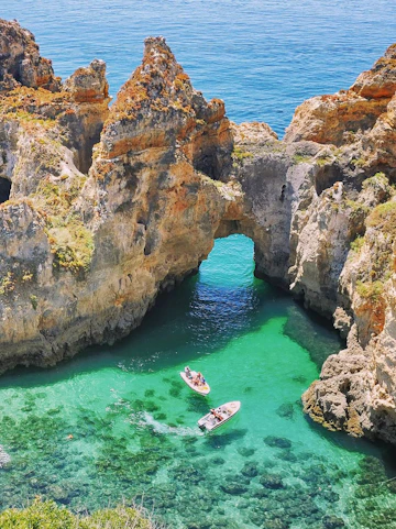Kayakers exploring rock formations in the ocean, Lagos, Algarve.