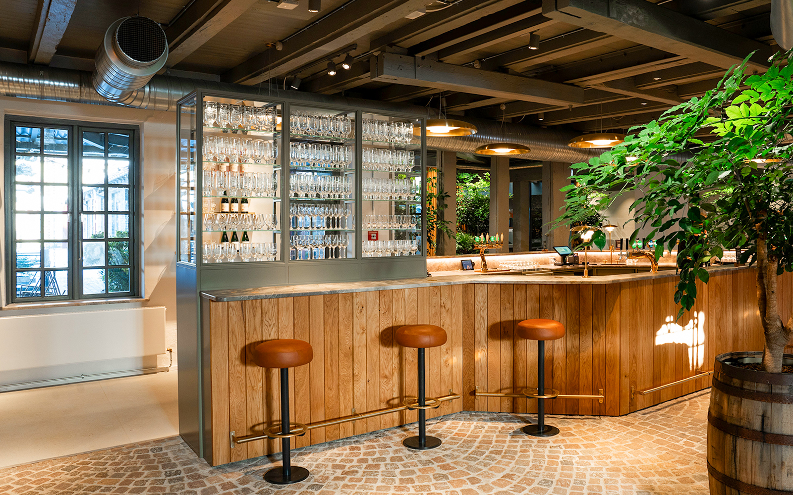 Bar area with stools and glassware display inside Home of Carlsberg exhibit.