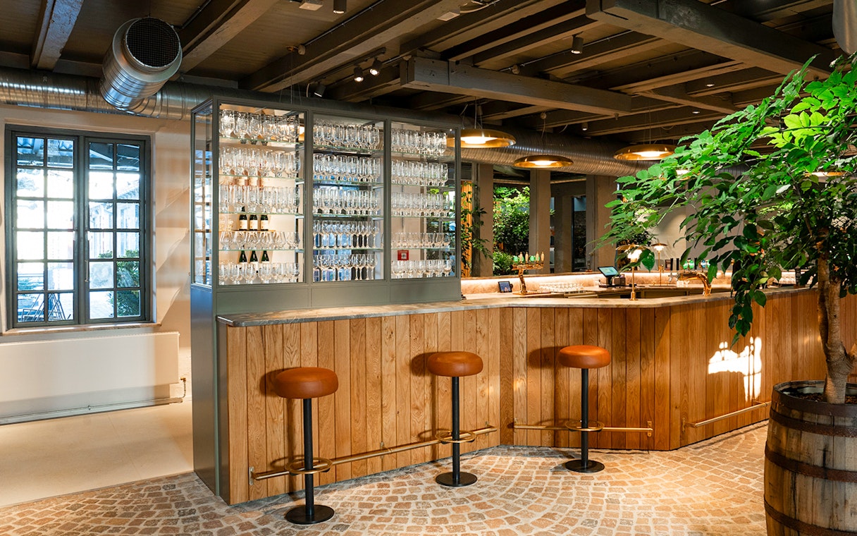 Bar area with stools and glassware display inside Home of Carlsberg exhibit.