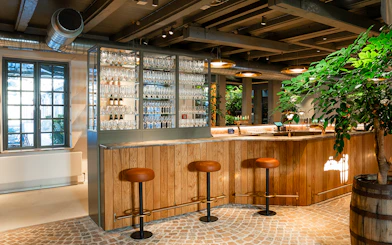 Bar area with stools and glassware display inside Home of Carlsberg exhibit.