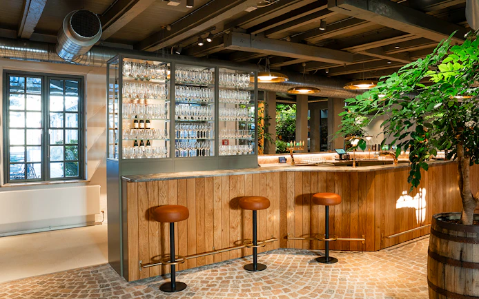 Bar area with stools and glassware display inside Home of Carlsberg exhibit.